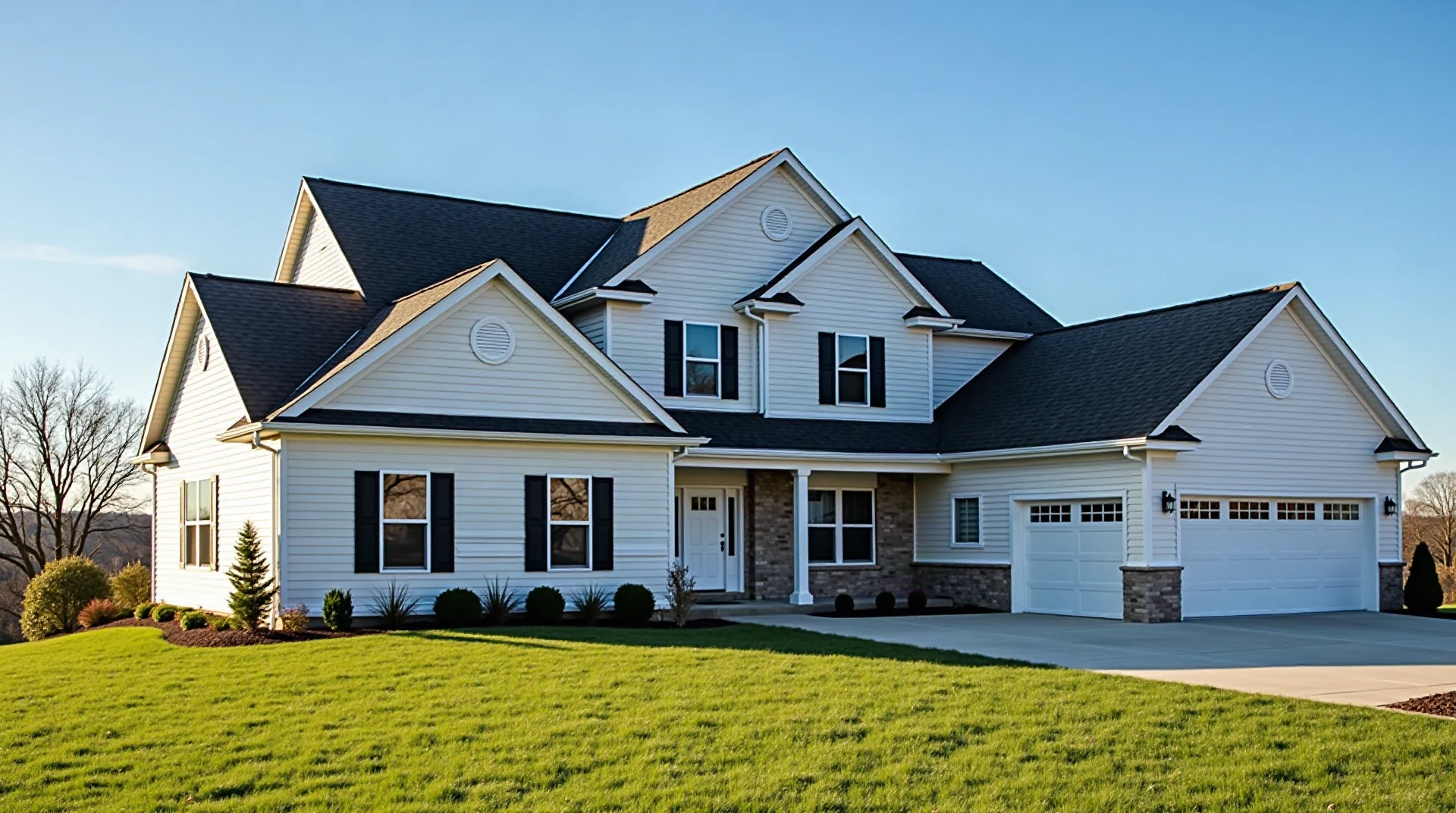 Upscale two-story suburban home with a newly installed charcoal architectural shingle roof, crisp ridge lines, clear blue sky, lawn in foreground, late afternoo